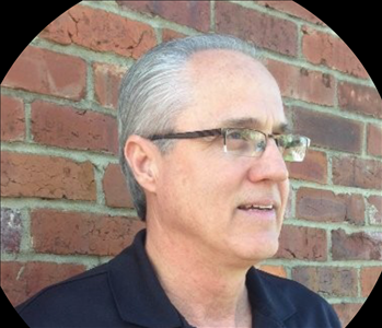 Man in front of brick wall 