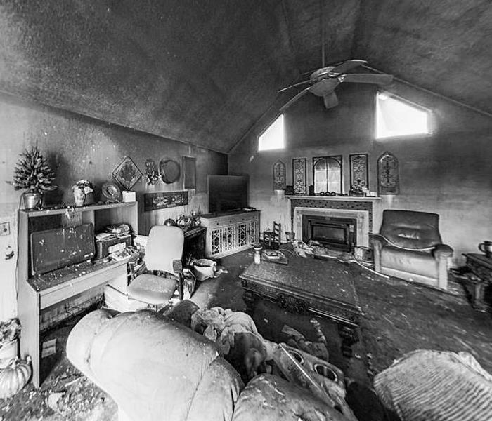 black and white photo of a living room with soot on the walls due to fire damage